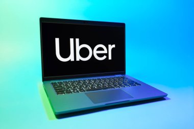 Prag, Çek Cumhuriyeti - 08 01 2025: Üniforma arka planda bir dizüstü bilgisayar Uber logosunu gösteriyor. Uber ulaşım ve dağıtım hizmetleri için bir gezinti selamlama uygulaması.