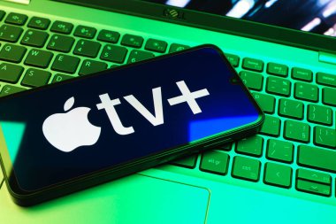 Prag, Çek Cumhuriyeti - 08 01 2025: Laptop klavyesinde uzanan bir cep telefonu Apple TV + logosunu gösteriyor. Apple TV +, filmler ve TV programları için bir yayın platformudur..