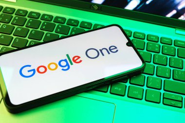 Prag, Çek Cumhuriyeti - 08 01 2025: Dizüstü bilgisayarda bulunan bir cep telefonu Google One logosunu görüntüler. Google 1 bulut depolama ve abonelik hizmetleri için bir platformdur.