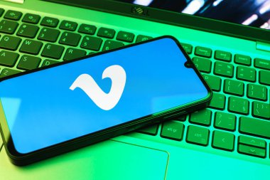 Prag, Çek Cumhuriyeti - 08 01 2025: Dizüstü bilgisayarın üzerinde duran bir cep telefonu Vimeo logosunu gösterir. Vimeo, yüksek kaliteli video sunucu ve paylaşımı için bir platformdur.