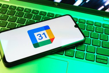 Prag, Çek Cumhuriyeti - 08 01 2025: Dizüstü bilgisayarda bulunan bir cep telefonu Google Takvim logosunu görüntüler. Google Takvimi olayları zamanlamak ve yönetmek için bir platformdur.