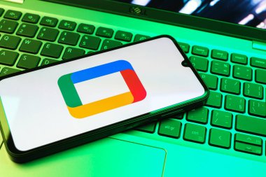 Prag, Çek Cumhuriyeti - 08 01 2025: Laptop klavyesinde uzanan bir cep telefonu Google TV logosunu gösteriyor. Google TV film, program ve uygulamalar için bir platformdur..