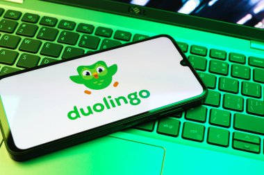 Prag, Çek Cumhuriyeti - 08 01 2025: Klavyenin üzerinde duran bir cep telefonu Duolingo logosunu gösteriyor. Duolingo interaktif olarak dil öğrenmek için bir platformdur..