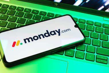 Prag, Çek Cumhuriyeti - 08 01 2025: Laptop klavyesinde duran bir cep telefonu Monday.com logosunu gösteriyor. Monday.com proje yönetimi ve takım işbirliği için bir platformdur.