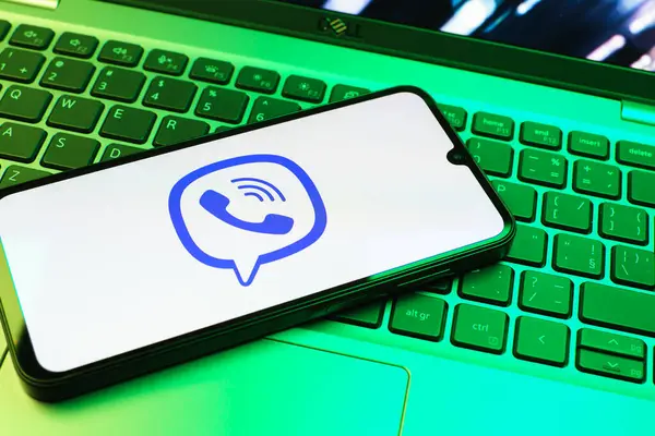 Prag, Çek Cumhuriyeti - 08 01 2025: Dizüstü bilgisayarın üzerinde duran bir cep telefonu Viber logosunu gösteriyor. Viber aramalar, mesajlar ve medya paylaşımı için bir mesajlaşma uygulamasıdır.