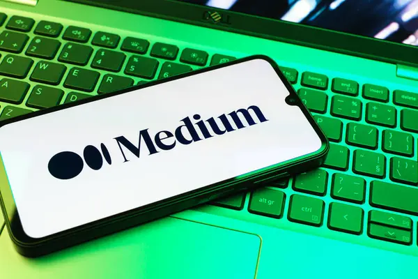 Prag, Çek Cumhuriyeti - 08 01 2025: Dizüstü bilgisayarın üzerinde duran bir cep telefonu Orta Yol logosunu gösterir. Medya, makale ve hikayeleri okumak ve yazmak için bir platformdur.