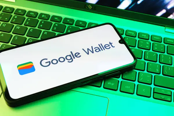 Prag, Çek Cumhuriyeti - 08 01 2025: Dizüstü bilgisayarda bulunan bir cep telefonu Google Cüzdan logosunu görüntüler. Google Cüzdanı dijital ödeme yöntemlerini depolamak ve kullanmak için bir platformdur.