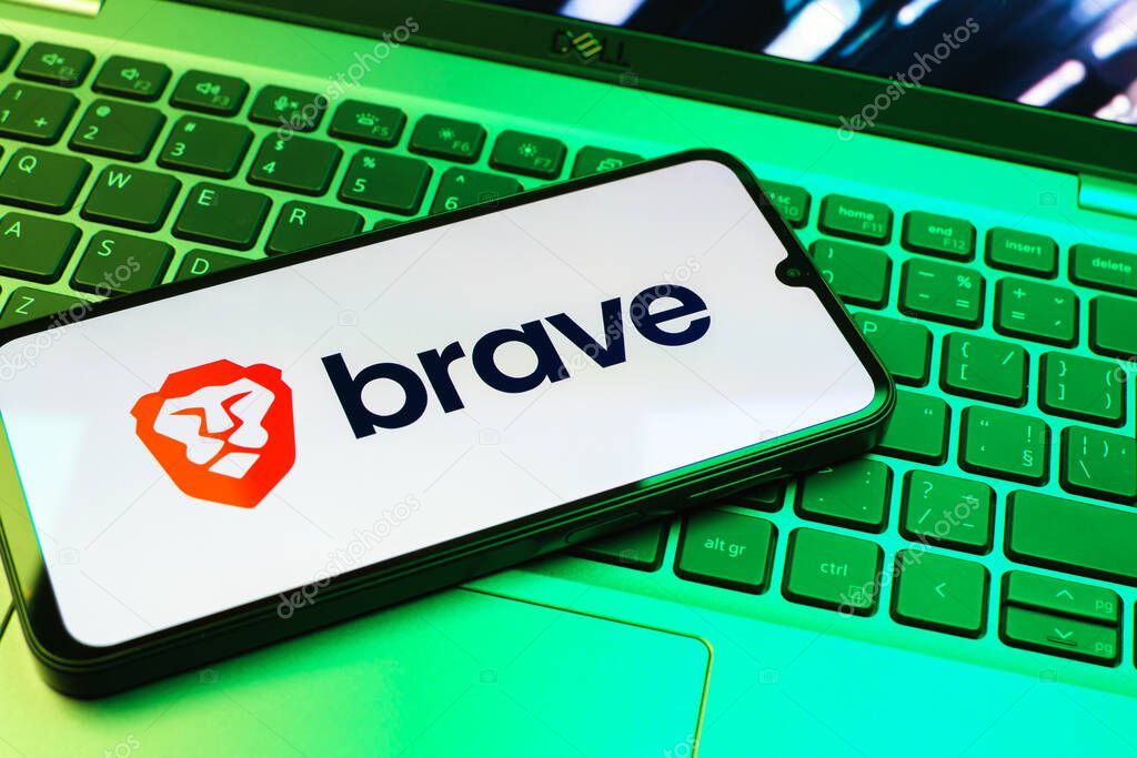 Prague, Czechia - 08 01 2025: A mobile phone lying on a laptop keyboard displays the Brave logo. Brave is a web browser focused on privacy and speed.