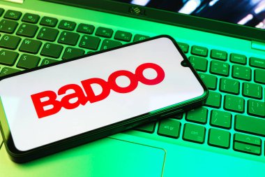 Prag, Çek Cumhuriyeti - 08 01 2025: Dizüstü bilgisayarın üzerinde duran bir cep telefonu Badoo logosunu gösteriyor. Badoo insanlarla tanışmak ve iletişim kurmak için bir randevu uygulaması..