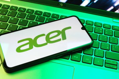 Prag, Çek Cumhuriyeti - 08 01 2025: Dizüstü bilgisayarın üzerinde duran bir cep telefonu Acer logosunu gösterir. Acer bilgisayar ve elektronik üreten bir teknoloji şirketidir..