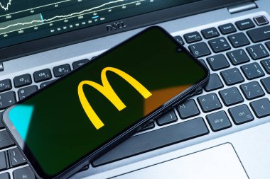 Prag, Çek Cumhuriyeti - 08 18 2025: Klavyede bir cep telefonu McDonalds logosu sergiler. McDonalds hamburger, patates kızartması ve daha fazlası sunan bir fast-food zinciri..