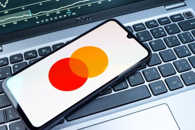 Prag, Çek Cumhuriyeti - 08 18 2025: Klavyede bir cep telefonu Mastercard logosu sergiler. Mastercard ödeme kartları ve hizmetler sağlayan bir finans şirketidir..