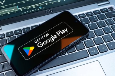 Prag, Çek Cumhuriyeti - 08 18 2025: Bir klavyede bir cep telefonu Google Play logosunu görüntüler. Google Play uygulamaları, oyunları ve dijital içeriği indirmek için bir platformdur.