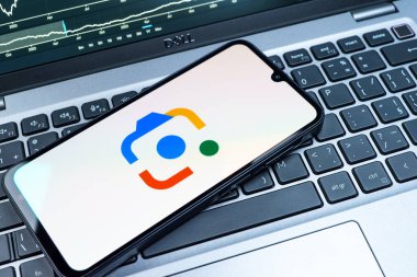 Prag, Çek Cumhuriyeti - 08 18 2025: Klavyede bir cep telefonu Google Lens logosunu görüntüler. Google Lens, resimlerdeki görsel arama ve bilgi için kullanılan bir araçtır..