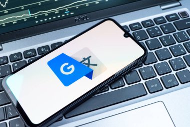 Prag, Çek Cumhuriyeti - 08 18 2025: Bir klavyede bir cep telefonu Google Translate logosunu görüntüler. Google Çevirisi metni ve konuşmayı diller arası çevirmek için bir platformdur..