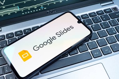 Prag, Çek Cumhuriyeti - 08 18 2025: Klavyede bir cep telefonu Google Slides logosunu görüntüler. Google Slides sunumlar ve slayt gösterileri oluşturmak için bir platformdur.
