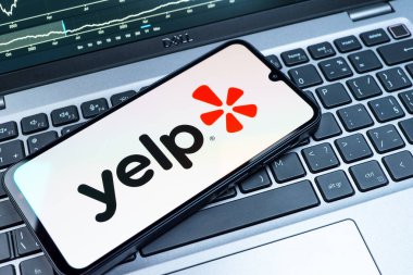 Prag, Çek Cumhuriyeti - 08 18 2025: Klavyede bir cep telefonu Yelp logosu sergiler. Yelp yerel işletmeleri bulmak ve incelemek için bir platformdur.