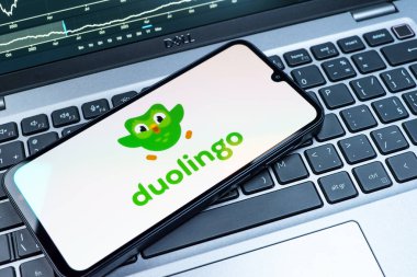 Prag, Çek Cumhuriyeti - 08 18 2025: Klavyede bir cep telefonu Duolingo logosu sergiler. Duolingo interaktif olarak dil öğrenmek için bir platformdur..