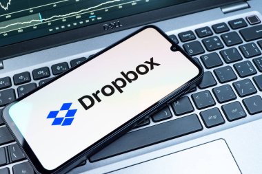 Prag, Çek Cumhuriyeti - 08 18 2025: Klavyede bir cep telefonu Dropbox logosu sergiler. Dropbox bulut depolama ve dosya paylaşımı için bir platformdur.