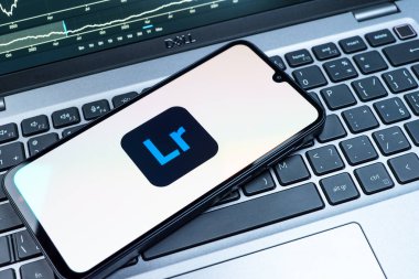 Prag, Çek Cumhuriyeti - 08 18 2025: Klavyede bir cep telefonu Lightroom logosunu gösteriyor. Lightroom fotoğraf düzenleme ve yönetim için bir yazılımdır..