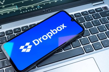 Prag, Çek Cumhuriyeti - 08 18 2025: Klavyede bir cep telefonu Dropbox logosu sergiler. Dropbox bulut depolama ve dosya paylaşımı için bir platformdur.