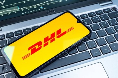Prag, Çek Cumhuriyeti - 08 18 2025: Klavyede bir cep telefonu DHL logosu sergiler. DHL uluslararası nakliye hizmeti sunan bir lojistik şirketidir..