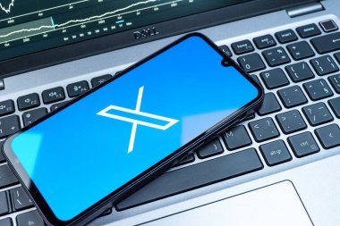 Prag, Çek Cumhuriyeti - 08 18 2025: Klavyede bir cep telefonu X logosu sergiler. X, kısa gönderileri ve güncellemeleri paylaşmak için bir platformdur.