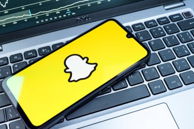 Prag, Çek Cumhuriyeti - 08 18 2025: Klavyede bir cep telefonu Snapchat logosu sergiler. Snapchat fotoğraf, video ve geçici mesajlar göndermek için bir uygulamadır.