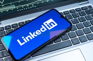 Prag, Çek Cumhuriyeti - 08 18 2025: Klavyede bir cep telefonu LinkedIn logosunu gösterir. LinkedIn, insanları ve şirketleri birbirine bağlayan profesyonel bir ağ..
