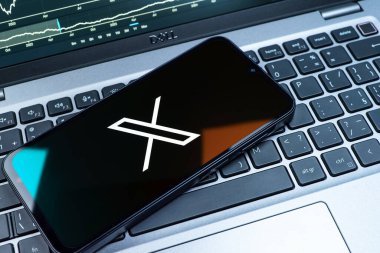 Prag, Çek Cumhuriyeti - 08 18 2025: Klavyede bir cep telefonu X logosu sergiler. X, kısa gönderileri ve güncellemeleri paylaşmak için bir platformdur.