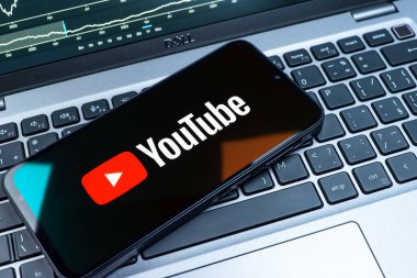 Prag, Çek Cumhuriyeti - 08 18 2025: Klavyede bir cep telefonu Youtube logosu sergiler. Youtube dünya çapında videoları izlemek ve paylaşmak için bir platform.