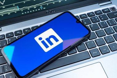Prag, Çek Cumhuriyeti - 08 18 2025: Klavyede bir cep telefonu LinkedIn logosunu gösterir. LinkedIn, insanları ve şirketleri birbirine bağlayan profesyonel bir ağ..