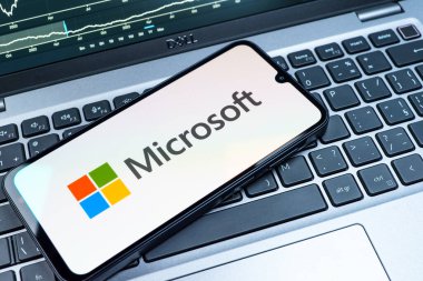 Prag, Çek Cumhuriyeti - 08 18 2025: Klavyede bir cep telefonu Microsoft logosu sergiler. Microsoft yazılım, donanım ve hizmet sunan bir teknoloji şirketidir..