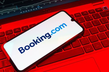 Prag, Çek Cumhuriyeti - 08 18 2025: Klavyede bir cep telefonu Booking.com logosu sergiler. Rezervasyon, otel bulmak ve rezervasyon yaptırmak için bir platformdur..