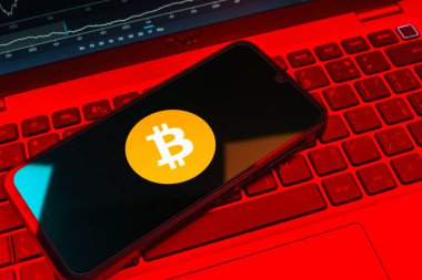 Prag, Çek Cumhuriyeti - 08 18 2025: Klavyede bir cep telefonu Bitcoin logosu sergiler. Bitcoin merkezi olmayan işlemler için dijital bir kripto para birimidir.