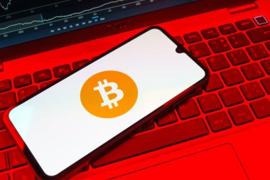 Prag, Çek Cumhuriyeti - 08 18 2025: Klavyede bir cep telefonu Bitcoin logosu sergiler. Bitcoin merkezi olmayan işlemler için dijital bir kripto para birimidir.