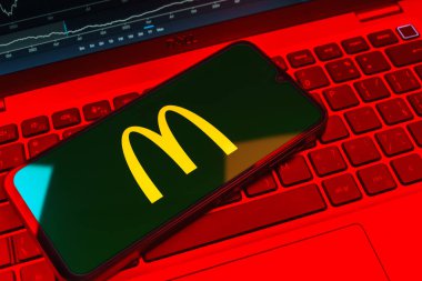 Prag, Çek Cumhuriyeti - 08 18 2025: Klavyede bir cep telefonu McDonalds logosu sergiler. McDonalds hamburger, patates kızartması ve daha fazlası sunan bir fast-food zinciri..