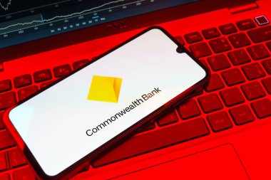Prag, Çek Cumhuriyeti - 08 18 2025: Bir klavyede bir cep telefonu Commonwealth Bank logosunu gösteriyor. Commonwealth Bank, Avustralya 'da finansal hizmetler sağlayan bir bankadır..