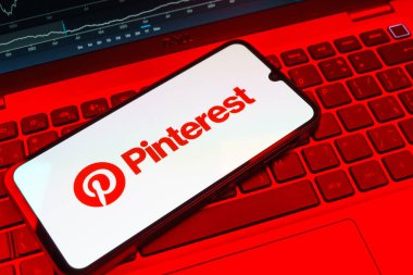 Prag, Çek Cumhuriyeti - 08 18 2025: Klavyede bir cep telefonu Pinterest logosunu gösteriyor. Pinterest fikirleri görsel olarak keşfetmek ve kaydetmek için bir platformdur..