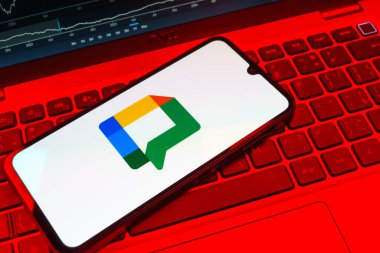 Prag, Çek Cumhuriyeti - 08 18 2025: Klavyede bir cep telefonu Google Chat logosunu görüntüler. Google Chat mesajlaşma ve takım işbirliği için bir platformdur.