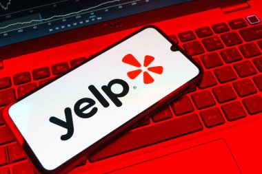 Prag, Çek Cumhuriyeti - 08 18 2025: Klavyede bir cep telefonu Yelp logosu sergiler. Yelp yerel işletmeleri bulmak ve incelemek için bir platformdur.