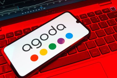 Prag, Çek Cumhuriyeti - 08 18 2025: Klavyede bir cep telefonu Agoda logosu sergiler. Agoda, otelleri ve seyahat yerlerini ayırtmak için bir platform..