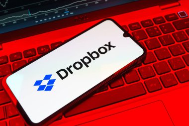 Prag, Çek Cumhuriyeti - 08 18 2025: Klavyede bir cep telefonu Dropbox logosu sergiler. Dropbox bulut depolama ve dosya paylaşımı için bir platformdur.