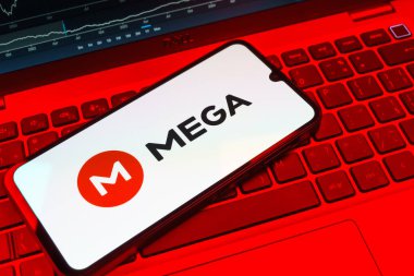 Prag, Çek Cumhuriyeti - 08 18 2025: Klavyede bir cep telefonu Mega logosu sergiler. Mega şifreli dosya paylaşımı ile bulut depolama platformu.