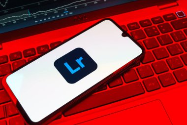 Prag, Çek Cumhuriyeti - 08 18 2025: Klavyede bir cep telefonu Lightroom logosunu gösteriyor. Lightroom fotoğraf düzenleme ve yönetim için bir yazılımdır..