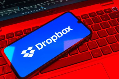 Prag, Çek Cumhuriyeti - 08 18 2025: Klavyede bir cep telefonu Dropbox logosu sergiler. Dropbox bulut depolama ve dosya paylaşımı için bir platformdur.
