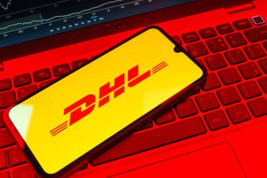 Prag, Çek Cumhuriyeti - 08 18 2025: Klavyede bir cep telefonu DHL logosu sergiler. DHL uluslararası nakliye hizmeti sunan bir lojistik şirketidir..