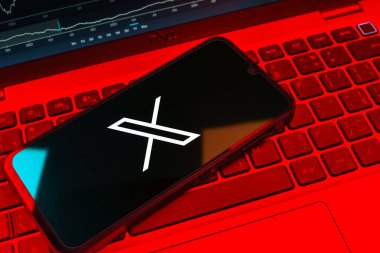 Prag, Çek Cumhuriyeti - 08 18 2025: Klavyede bir cep telefonu X logosu sergiler. X, kısa gönderileri ve güncellemeleri paylaşmak için bir platformdur.