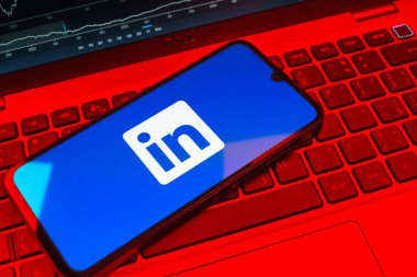 Prag, Çek Cumhuriyeti - 08 18 2025: Klavyede bir cep telefonu LinkedIn logosunu gösterir. LinkedIn, insanları ve şirketleri birbirine bağlayan profesyonel bir ağ..