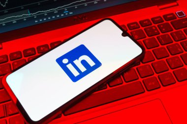 Prag, Çek Cumhuriyeti - 08 18 2025: Klavyede bir cep telefonu LinkedIn logosunu gösterir. LinkedIn, insanları ve şirketleri birbirine bağlayan profesyonel bir ağ..